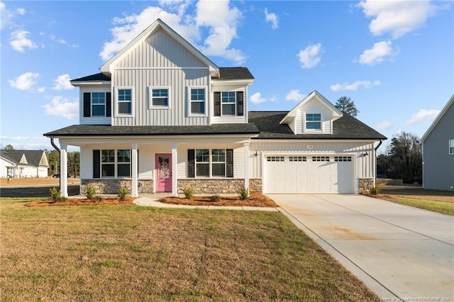 view of front of property featuring a front yard, a porch, and a garage