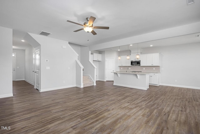 unfurnished living room with ceiling fan and dark hardwood / wood-style floors