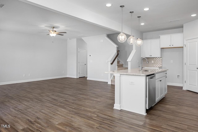 kitchen featuring white cabinetry, decorative backsplash, sink, pendant lighting, and an island with sink