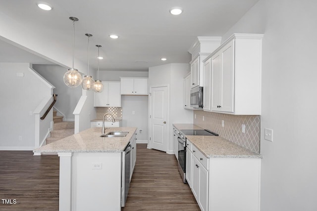 kitchen with sink, a center island with sink, white cabinets, and stainless steel appliances