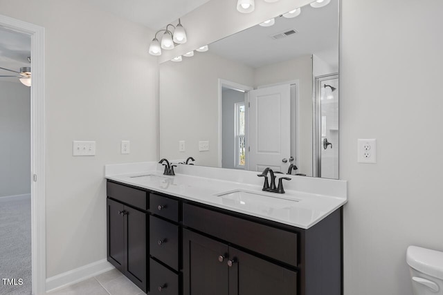 bathroom featuring tile patterned flooring, ceiling fan, toilet, a shower with shower door, and vanity