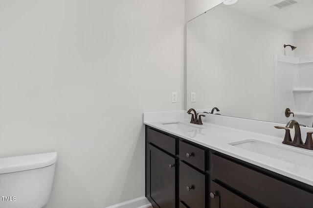 bathroom with toilet, walk in shower, and vanity