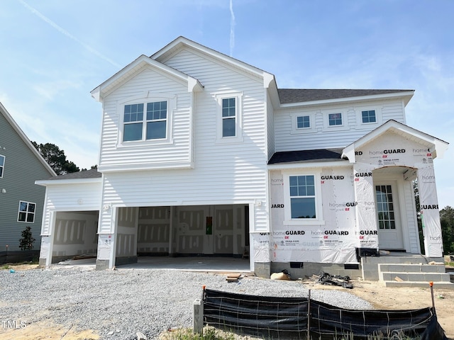 view of front of property with roof with shingles, driveway, and a garage