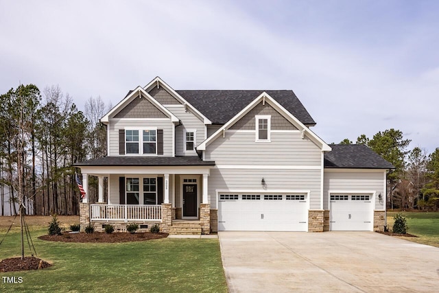 craftsman inspired home featuring a porch, a garage, a front yard, and driveway