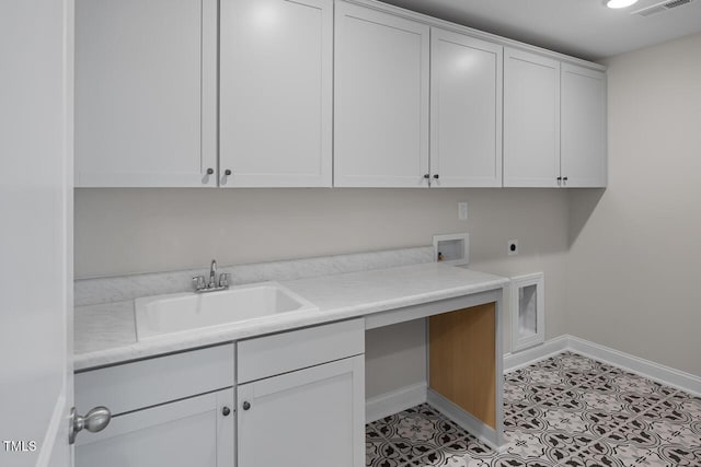 laundry room with electric dryer hookup, baseboards, cabinet space, and a sink