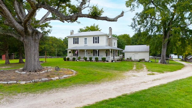 farmhouse featuring covered porch and a front yard