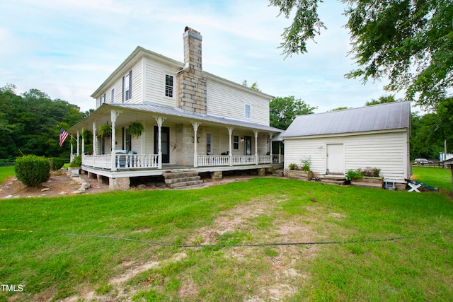 rear view of property featuring a lawn and a porch