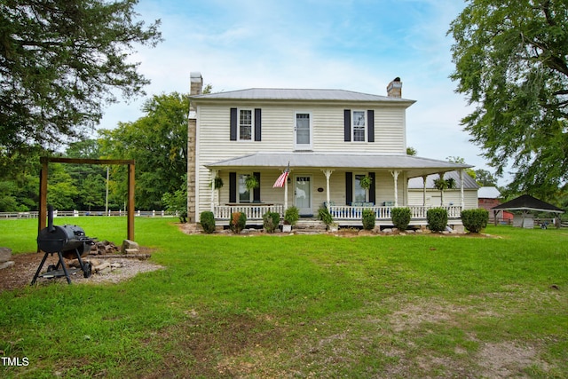 view of front of property featuring a porch, a chimney, and a front yard