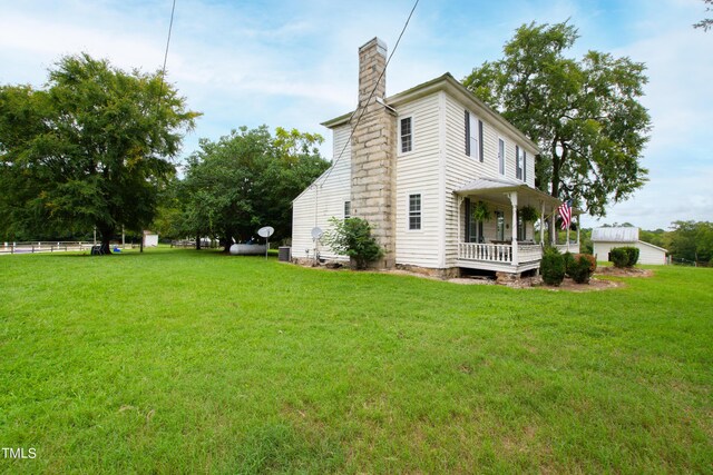 view of home's exterior featuring covered porch and a lawn