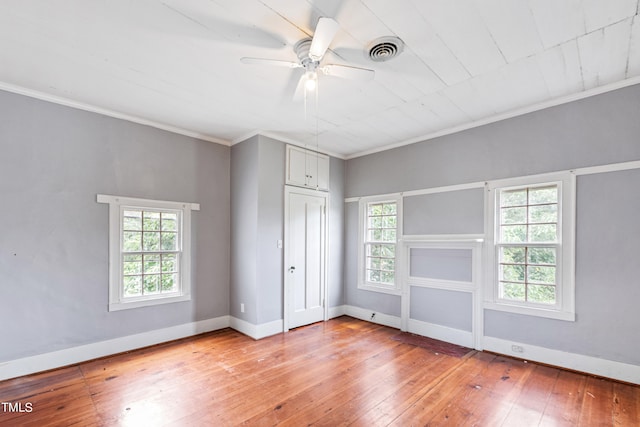 unfurnished bedroom featuring hardwood / wood-style floors, ornamental molding, a closet, and ceiling fan