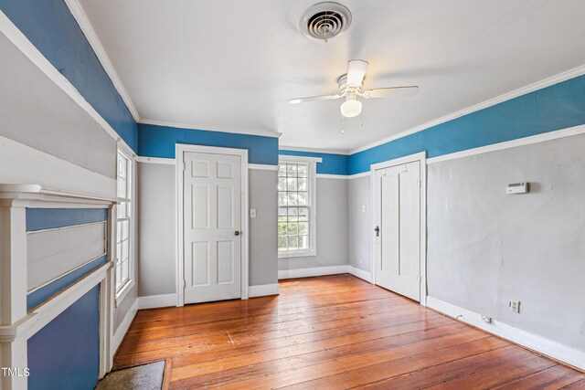 unfurnished bedroom with ceiling fan, wood-type flooring, and ornamental molding