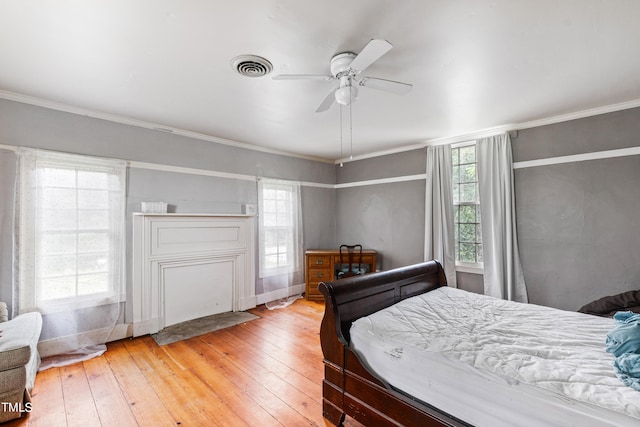 bedroom featuring ceiling fan, light wood-type flooring, and ornamental molding