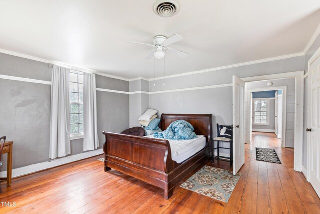 bedroom featuring ceiling fan, ornamental molding, and hardwood / wood-style floors