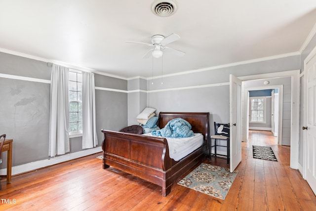 bedroom featuring visible vents, crown molding, light wood finished floors, and ceiling fan