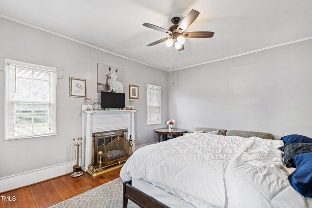 bedroom with ceiling fan, crown molding, and hardwood / wood-style flooring