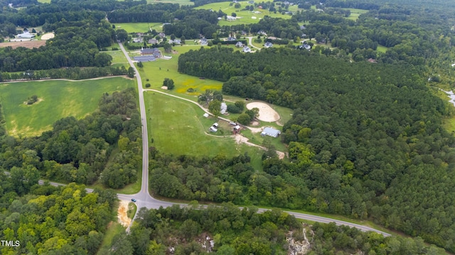 bird's eye view with a wooded view