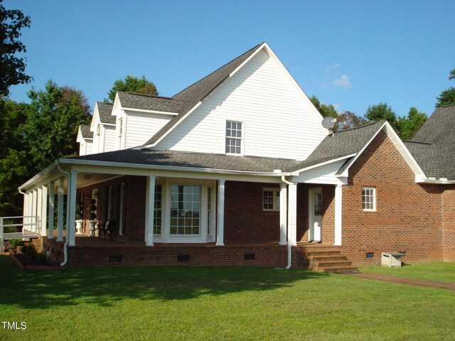 back of property with a yard and covered porch