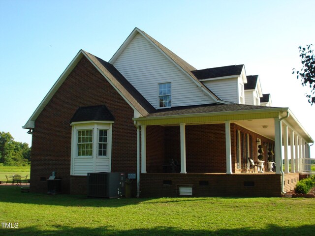 rear view of house with a yard and cooling unit