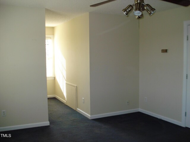 carpeted spare room with a textured ceiling and ceiling fan