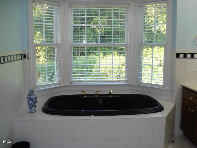 bathroom with vanity and tiled bath