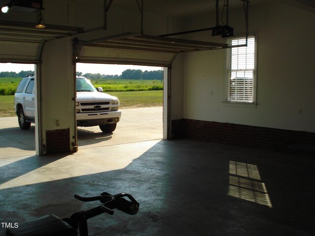 garage with a rural view and a garage door opener