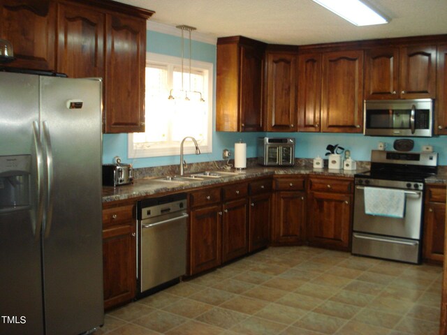 kitchen with pendant lighting, stainless steel appliances, crown molding, and sink