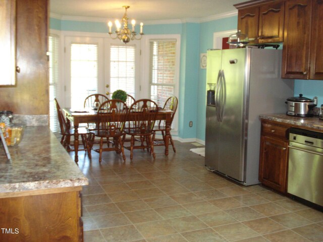 kitchen featuring ornamental molding, hanging light fixtures, an inviting chandelier, and appliances with stainless steel finishes