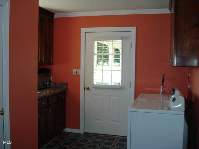 washroom featuring crown molding, cabinets, and washing machine and dryer