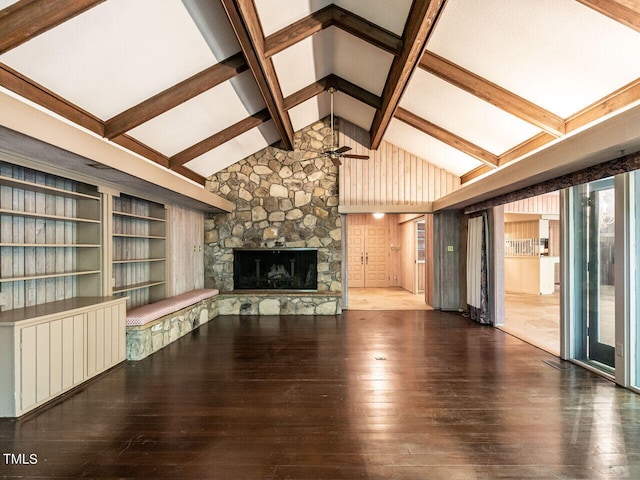 unfurnished living room featuring a fireplace, built in features, wood-type flooring, and beam ceiling