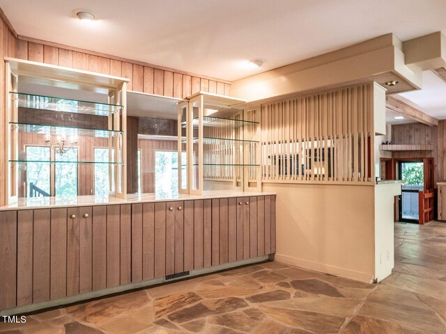 kitchen featuring kitchen peninsula and wood walls