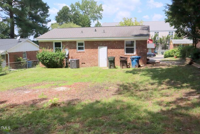 back of property with cooling unit and a yard