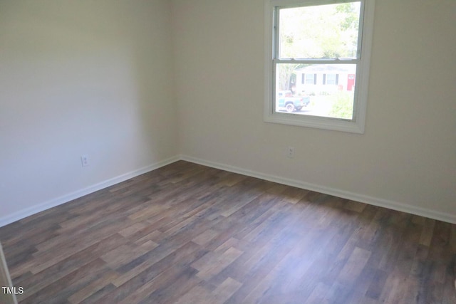 unfurnished room with dark hardwood / wood-style flooring