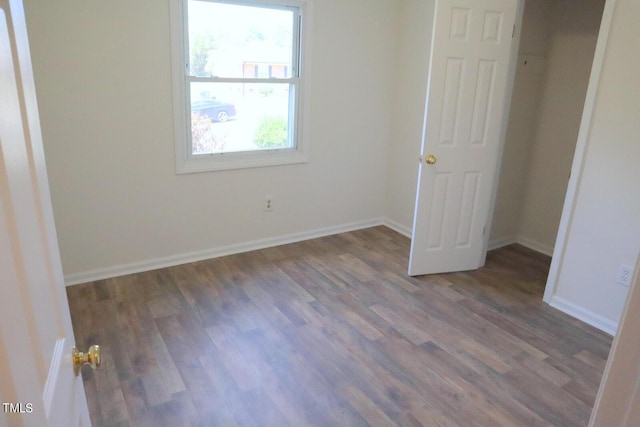 unfurnished bedroom with dark wood-type flooring