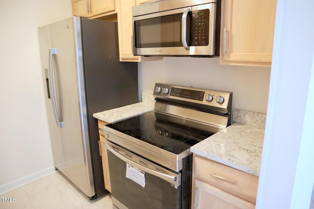 kitchen featuring light brown cabinetry, light stone countertops, and stainless steel appliances