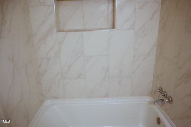 bathroom featuring tiled shower / bath