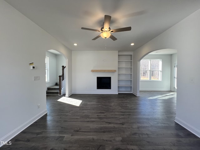 unfurnished living room featuring ceiling fan and dark hardwood / wood-style flooring