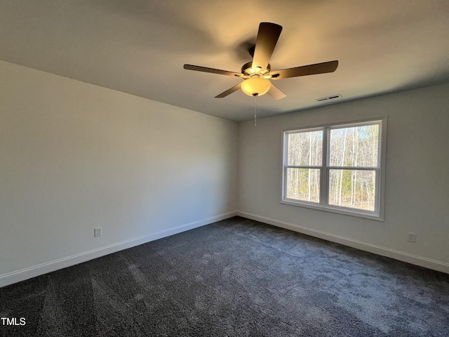 unfurnished room with ceiling fan and dark carpet