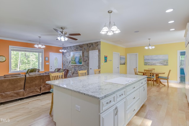 kitchen with light wood-style flooring, a healthy amount of sunlight, and ornamental molding