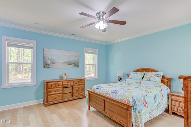 bedroom featuring visible vents, ornamental molding, wood finished floors, baseboards, and ceiling fan