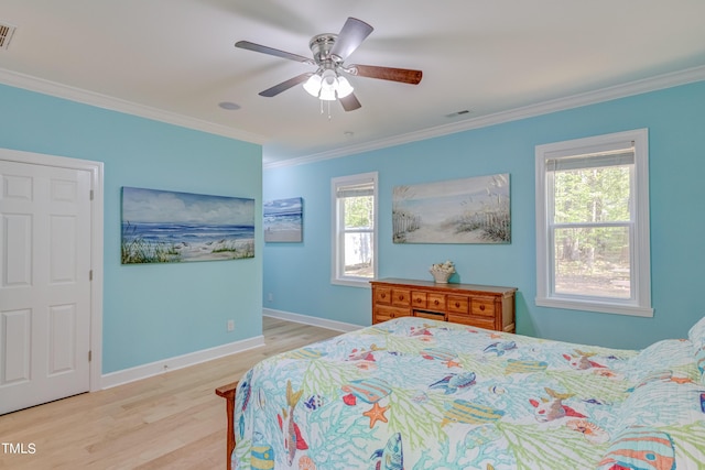 bedroom with visible vents, baseboards, light wood-style floors, and ornamental molding