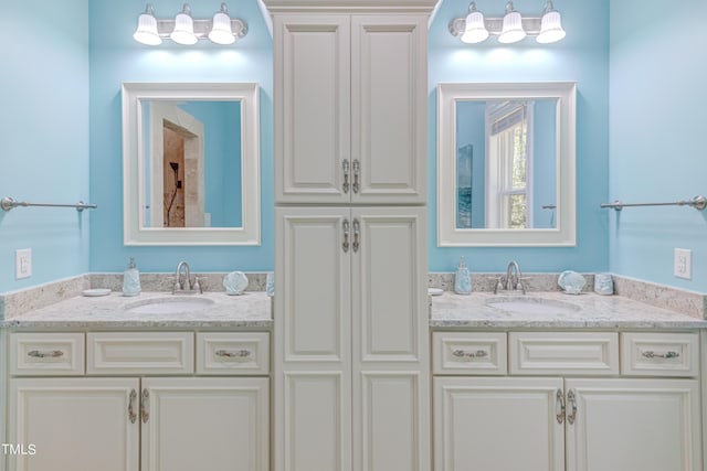 full bathroom with double vanity and a sink