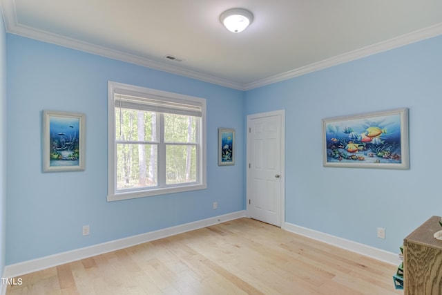 interior space featuring light wood-style flooring, baseboards, and ornamental molding