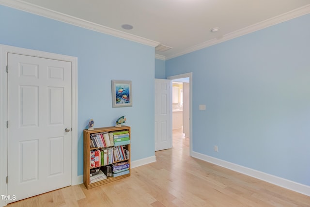 interior space with wood finished floors, baseboards, and ornamental molding