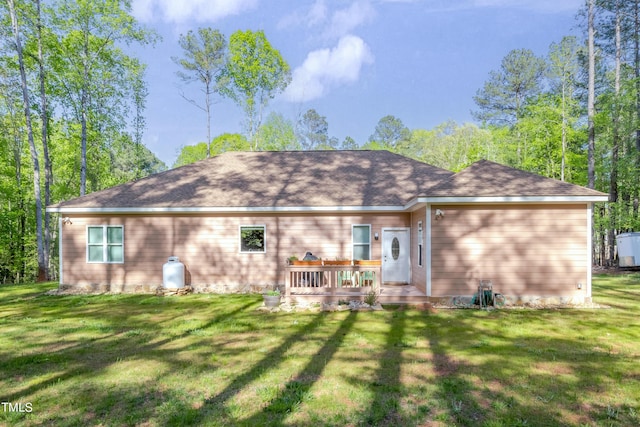 rear view of property with a yard and a wooden deck