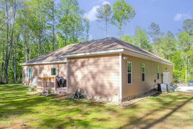 rear view of house with a yard, central AC, and a wooden deck