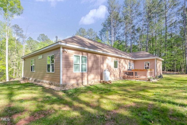 back of house featuring a lawn and a deck