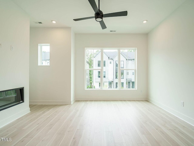 unfurnished living room featuring ceiling fan and light wood-type flooring