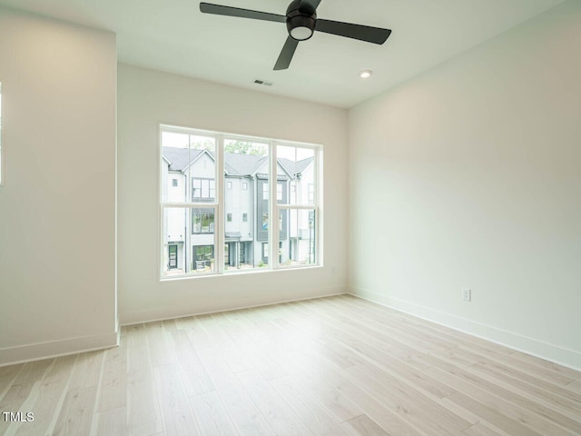 spare room with light wood-type flooring and ceiling fan