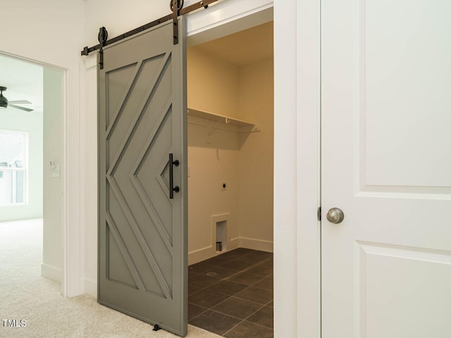 laundry area with carpet flooring, hookup for an electric dryer, a barn door, and ceiling fan