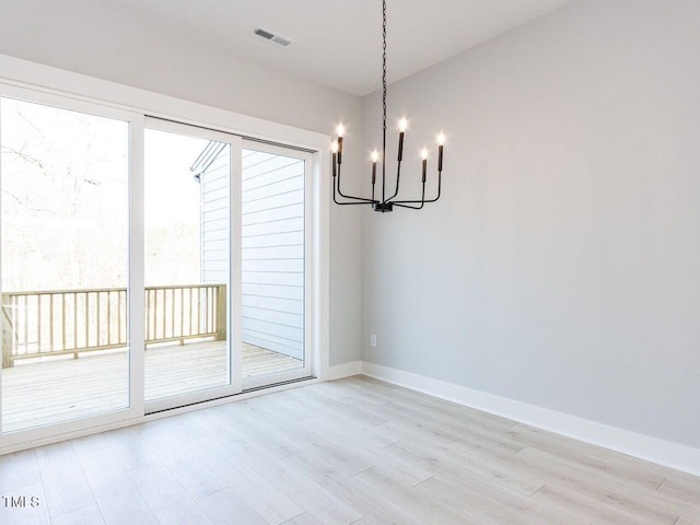 interior space with light wood-type flooring, an inviting chandelier, baseboards, and visible vents